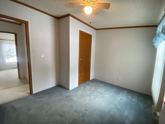 unfurnished bedroom featuring ceiling fan, crown molding, carpet floors, and a textured ceiling