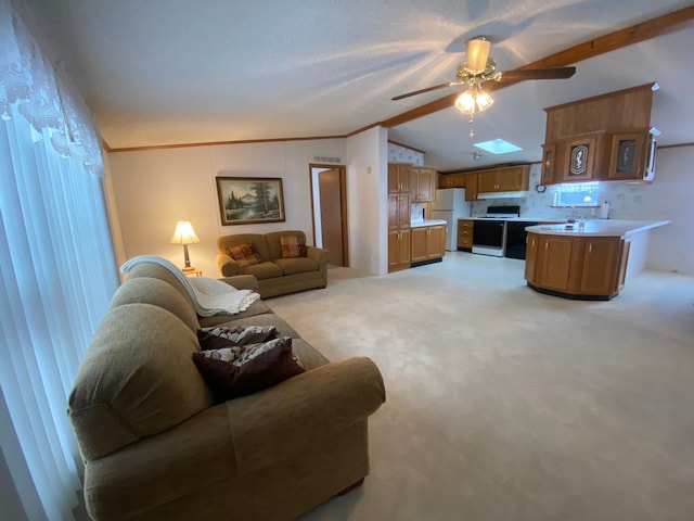 living room with light colored carpet, ornamental molding, lofted ceiling with skylight, and ceiling fan