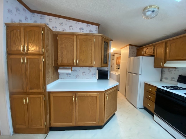 kitchen with white refrigerator, gas range, crown molding, and a textured ceiling