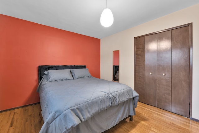 bedroom with light hardwood / wood-style floors and a closet