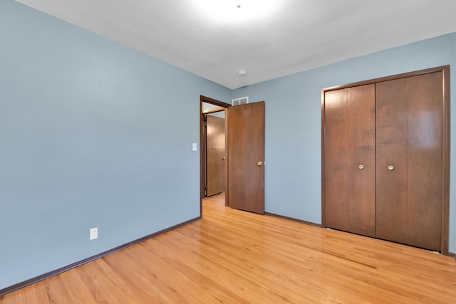 unfurnished bedroom featuring a closet and light wood-type flooring