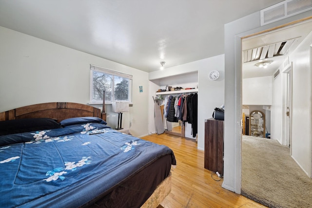 bedroom featuring hardwood / wood-style flooring, a walk in closet, and a closet