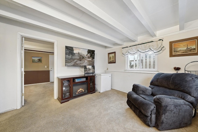 living area featuring beamed ceiling and carpet floors