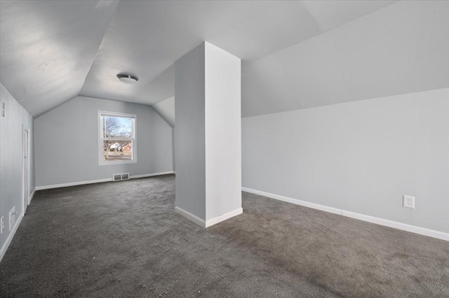 bonus room with lofted ceiling and dark colored carpet