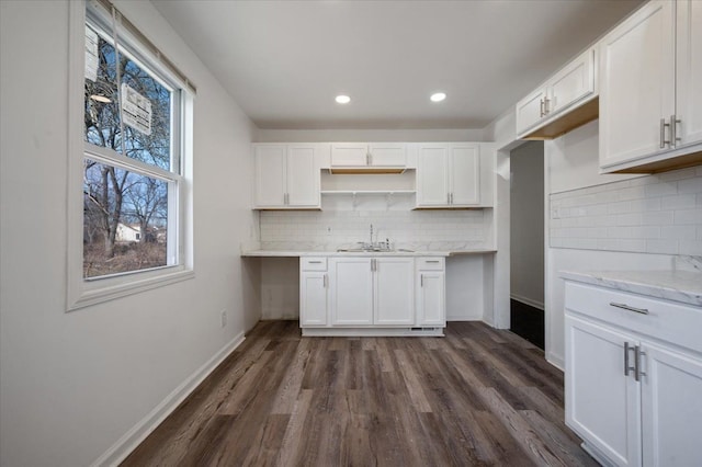 kitchen with tasteful backsplash, white cabinetry, sink, and dark hardwood / wood-style floors