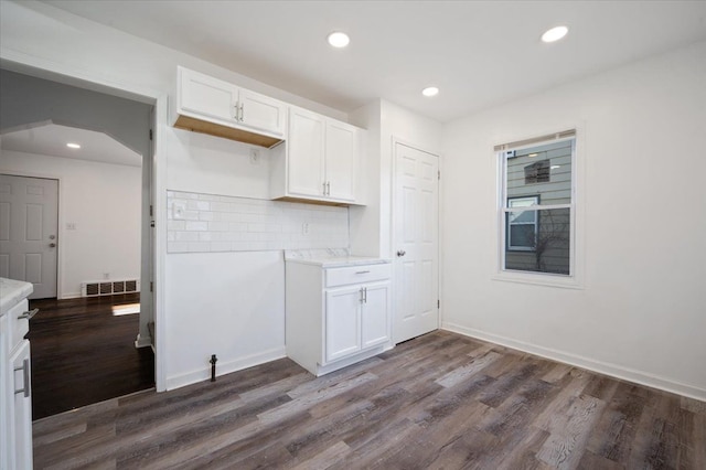 kitchen with dark hardwood / wood-style floors, decorative backsplash, and white cabinets