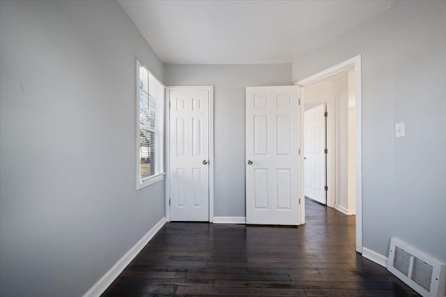 unfurnished bedroom with dark wood-type flooring