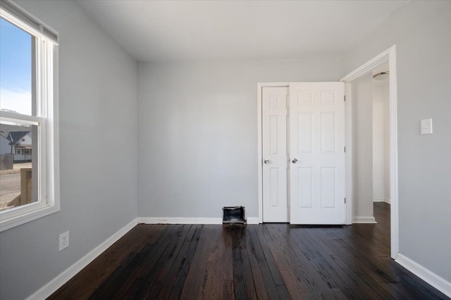 empty room with dark hardwood / wood-style flooring