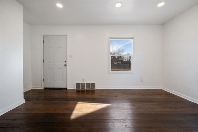 unfurnished room with dark wood-type flooring