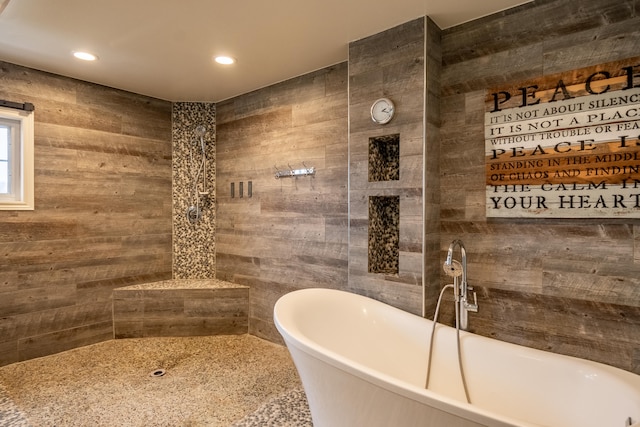 bathroom with tile walls and a bathtub