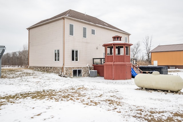 snow covered back of property with central AC unit