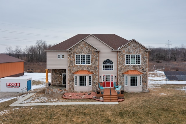 view of front of property with solar panels and a front lawn