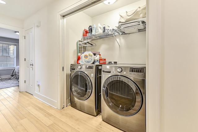 washroom featuring separate washer and dryer and light hardwood / wood-style flooring