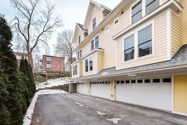 snow covered property with a garage