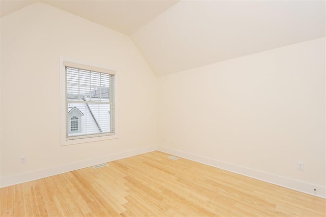 empty room featuring hardwood / wood-style flooring and lofted ceiling