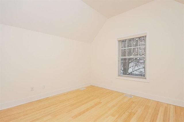 spare room with lofted ceiling and hardwood / wood-style floors