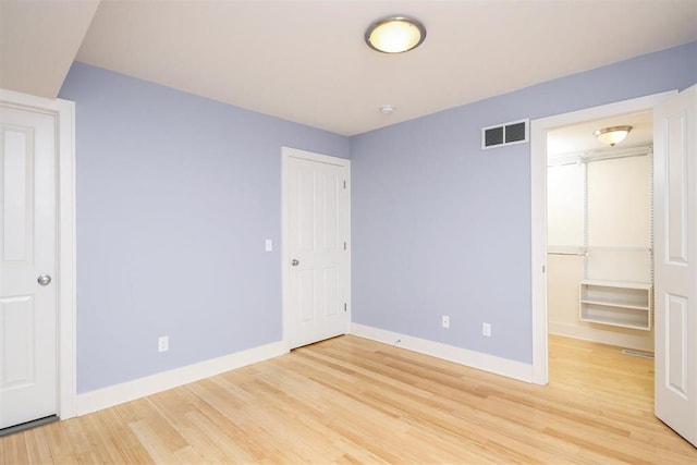 unfurnished bedroom with light hardwood / wood-style floors and a closet