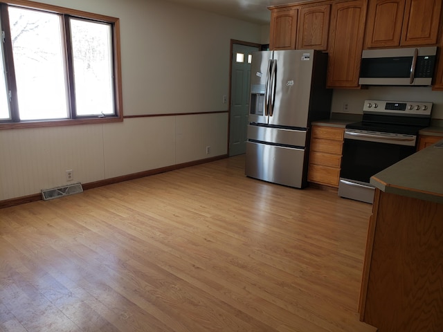 kitchen featuring appliances with stainless steel finishes and light hardwood / wood-style flooring