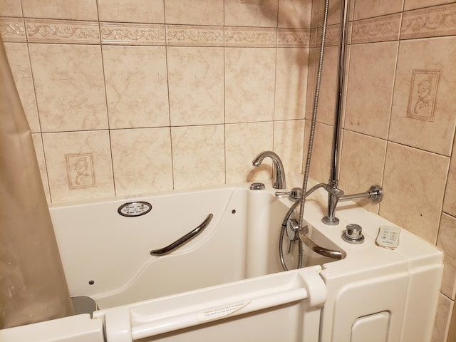 bathroom with a tub and tile walls