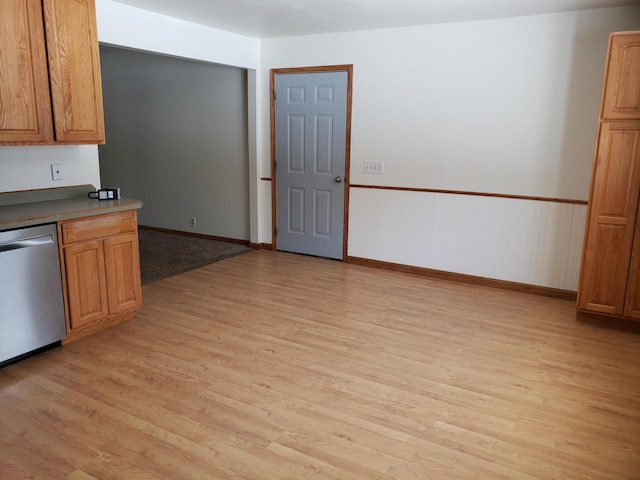 kitchen with light hardwood / wood-style flooring and stainless steel dishwasher