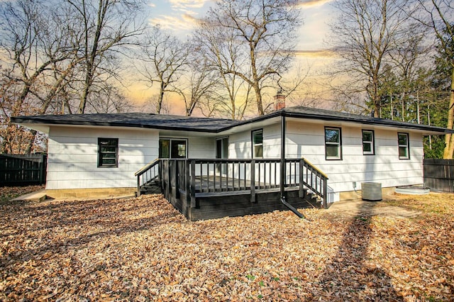 back house at dusk with a deck