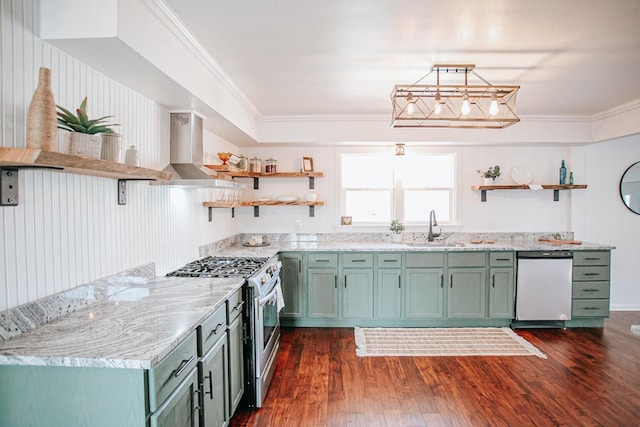 kitchen with sink, green cabinetry, stainless steel appliances, crown molding, and wall chimney exhaust hood