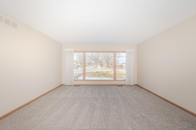 unfurnished room featuring baseboards, lofted ceiling, and light colored carpet