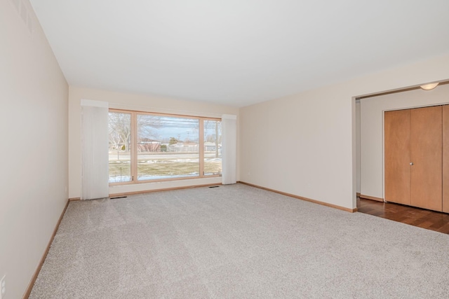 carpeted spare room featuring baseboards