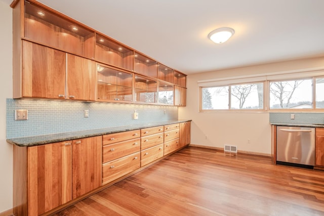 kitchen with visible vents, decorative backsplash, dark stone counters, light wood-style floors, and stainless steel dishwasher