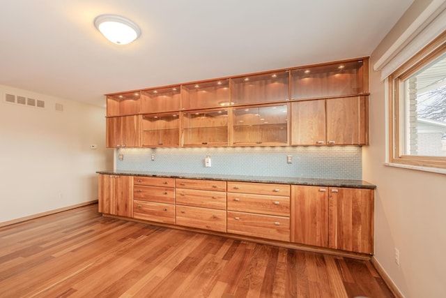 kitchen featuring visible vents, backsplash, and wood finished floors