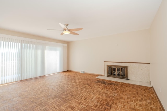 unfurnished living room featuring a fireplace with flush hearth, visible vents, ceiling fan, and baseboards