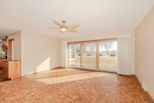 unfurnished living room with visible vents, baseboards, and ceiling fan