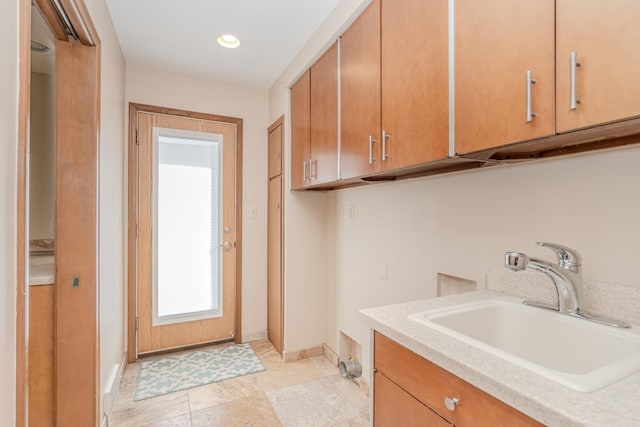 laundry area featuring cabinet space, baseboards, a sink, and recessed lighting