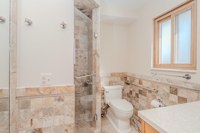 full bath with a wainscoted wall, tile walls, toilet, a tile shower, and vanity