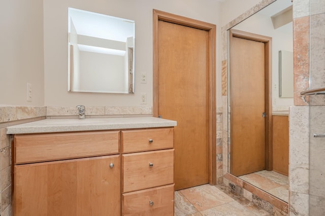 bathroom featuring stone tile flooring and vanity