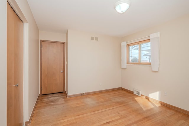 unfurnished bedroom featuring light wood finished floors, visible vents, and baseboards