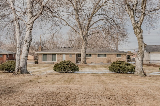 ranch-style home featuring brick siding and a chimney