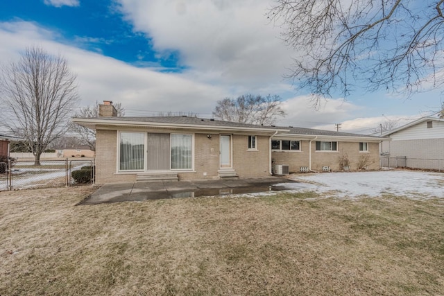 back of property with brick siding, fence, a lawn, and a patio