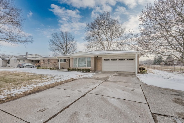 view of front of home with a garage, concrete driveway, and brick siding