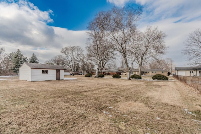 view of yard with fence and an outbuilding