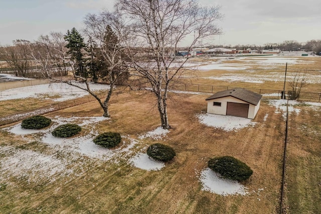 yard covered in snow with fence and an outdoor structure