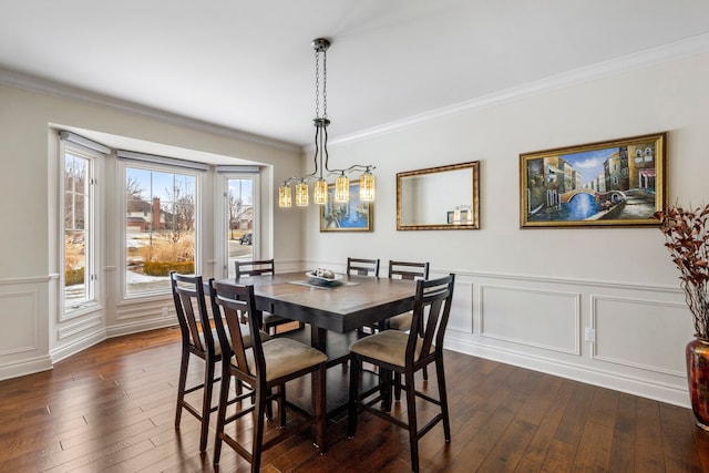 dining area with ornamental molding, dark wood finished floors, and a decorative wall