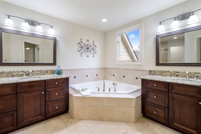 bathroom with two vanities, a garden tub, a sink, and tile patterned floors