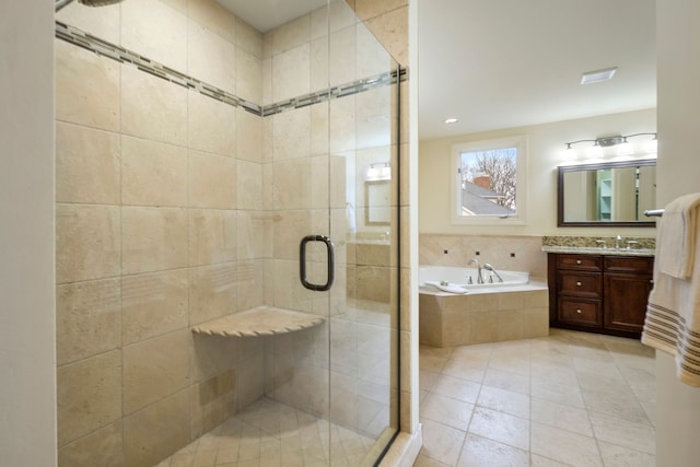 bathroom with visible vents, vanity, a bath, tile patterned floors, and a stall shower