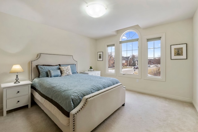 bedroom featuring light carpet and baseboards