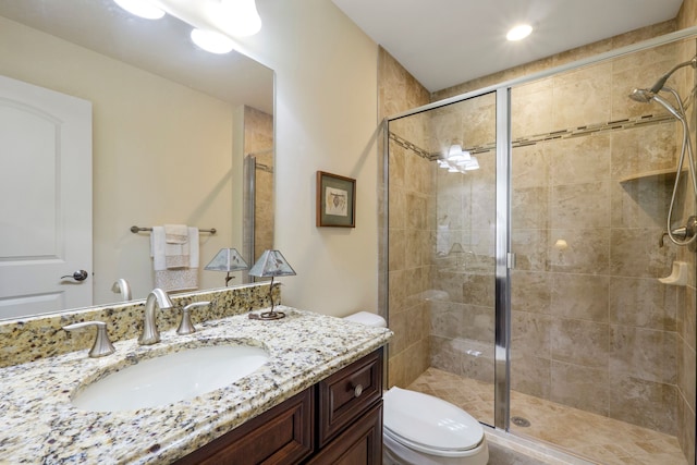 bathroom with toilet, a stall shower, and vanity