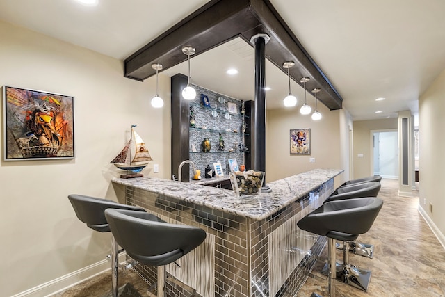 bar with pendant lighting, beamed ceiling, indoor wet bar, and baseboards