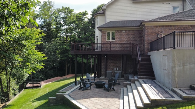 back of house featuring a patio area, stairway, a lawn, and brick siding