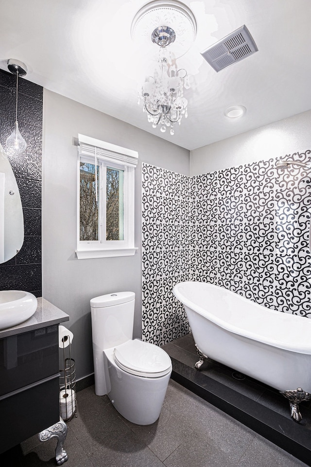 bathroom featuring a tub to relax in, toilet, a chandelier, and vanity