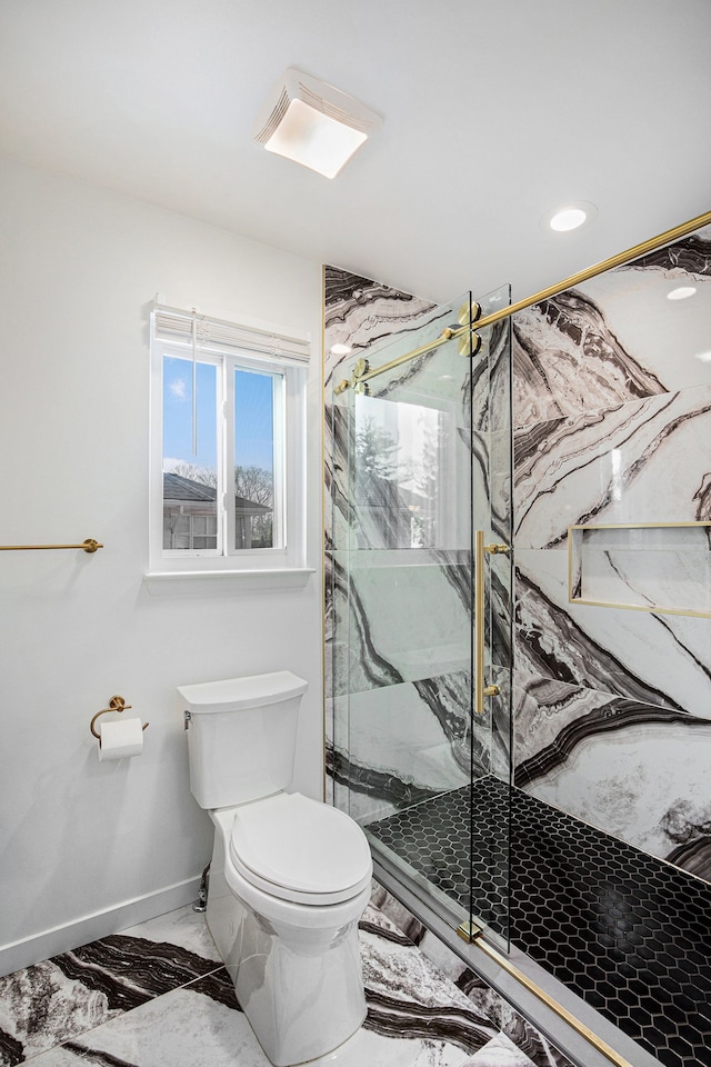 bathroom with a shower with door and toilet